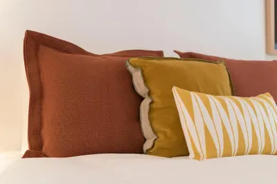 a pile of pillows sitting on top of a bed at BmyGuest Collection - Downtown Mezzanine Apartment in Porto