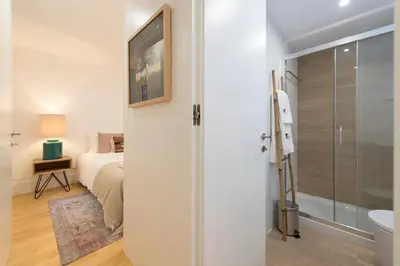 a bedroom with a bed and a bathroom with a shower at BmyGuest Collection - Downtown Mezzanine Apartment in Porto