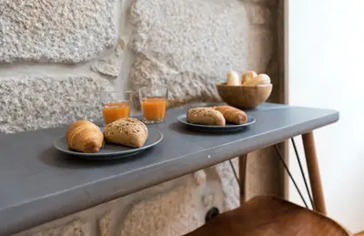 a table with two plates of bread and two glasses of orange juice at LovelyStay - Rico's Apartment - Almada 2º F in Porto