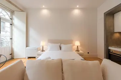 a white bedroom with a bed and two couches at LovelyStay - Rico's Apartment - Almada 2º F in Porto
