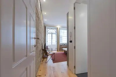 a hallway with a white door and a chair at LovelyStay - Rico's Apartment - Almada 2º F in Porto