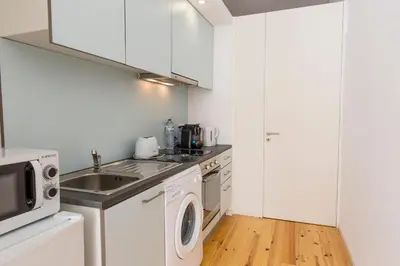 a kitchen with a sink and a washing machine at Downtown Porto Bonfim Studio Apt in Porto
