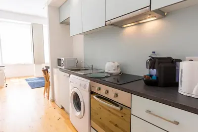 a kitchen with a washer and dryer on a counter at Downtown Porto Bonfim Studio Apt in Porto