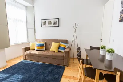 a living room with a couch and a table at Downtown Porto Bonfim Studio Apt in Porto