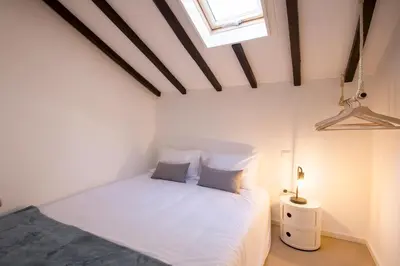 a bedroom with a white bed and a window at Republica Apartments at D. Luis I Bridge in Vila Nova de Gaia
