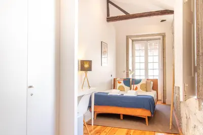a bedroom with a bed and a table at LovelyStay - Dirk Apartment Almada 3º T in Porto