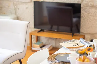 a living room with a television and a table with food at LovelyStay - Dirk Apartment Almada 3º T in Porto
