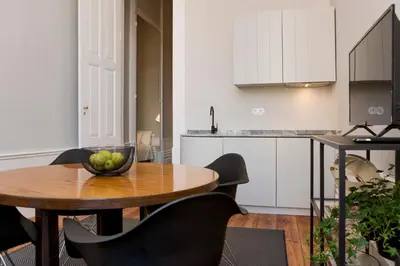 a kitchen and a table with a bowl of fruit on it at AD Apartment - Solar da Avenida in Porto