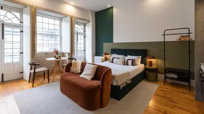 a bedroom with a bed and a chair and a table at LovelyStay - Allderman Apartment - Almada 3º F in Porto