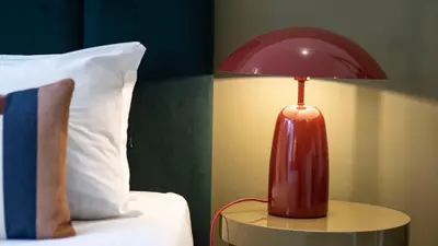 a red lamp sitting on a table next to a pillow at LovelyStay - Allderman Apartment - Almada 3º F in Porto
