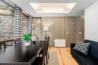 a dining room with a black table and a couch at OX Apartments B Places in Porto