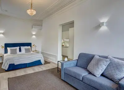 a bedroom with a bed and a blue couch at ApartmentsPorto - Bombarda 451 in Porto
