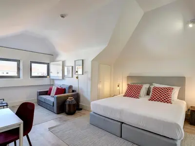 a bedroom with a large bed and a couch at ApartmentsPorto - Bombarda 451 in Porto