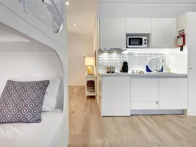 a white room with a bed and a microwave at ApartmentsPorto - Bombarda 451 in Porto