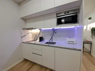 a white kitchen with a sink and a microwave at Casa de Cristal by Oporto Soul in Porto