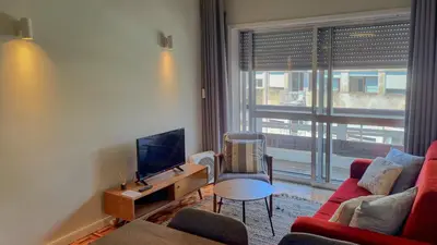 a living room with a red couch and a tv at Oporto Downtown in Porto
