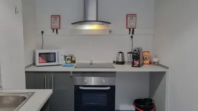 a small kitchen with a sink and a microwave at Oporto Downtown in Porto