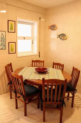 a dining room with a wooden table and chairs at Porto Patricio Apartments in Porto