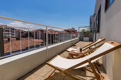 a balcony with two deck chairs on a building at Porto Haven - Terrace Penthouse in Downtown in Porto