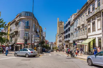 a busy city street with cars and people crossing the street at Porto Haven - Terrace Penthouse in Downtown in Porto
