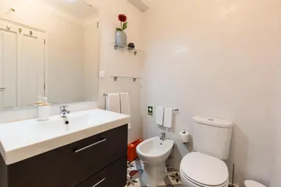 a white bathroom with a toilet and a sink at Porto Haven - Marquês Downtown in Porto