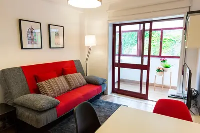 a living room with a red couch and a sliding glass door at Porto Haven - Marquês Downtown in Porto