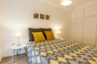 a bedroom with a bed with yellow pillows and a table at Porto Haven - Marquês Downtown in Porto