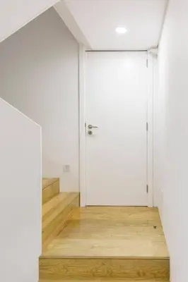 a room with a white door and a wooden floor at APOSENTUS - Your home at Pinheiro's Residence in Porto