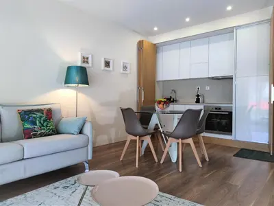 a living room with a couch and a table and chairs at Trindade Apartments in Porto