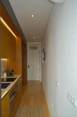 a kitchen with yellow cabinets and a white door at Camões by Trindade Sweet Home in Porto