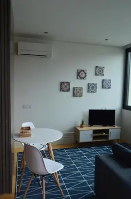 a living room with a white table and a tv at Camões by Trindade Sweet Home in Porto