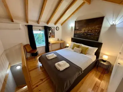 a bedroom with a large bed with two towels on it at Mezzanine cozy house in Porto