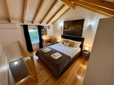 a bedroom with a large bed in a room at Mezzanine cozy house in Porto
