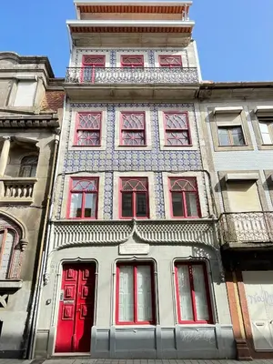 a tall building with red doors and windows at Mezzanine cozy house in Porto