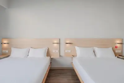 two beds in a room with white walls at Moov Hotel Porto Centro in Porto
