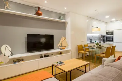 a living room with a couch and a tv and a table at Merc Porto Cedofeita Place in Porto
