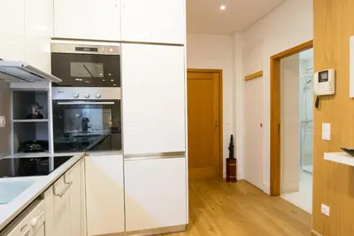 a kitchen with white cabinets and a refrigerator at Merc Porto Cedofeita Place in Porto
