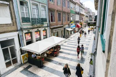 a group of people walking down a city street at Merc Porto Cedofeita Place in Porto