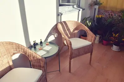 two wicker chairs and a table in a room at A Casa da Maria in Porto