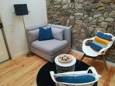 a living room with a couch and a chair at APOSENTUS - Your home with a remarkable view in Vila Nova de Gaia