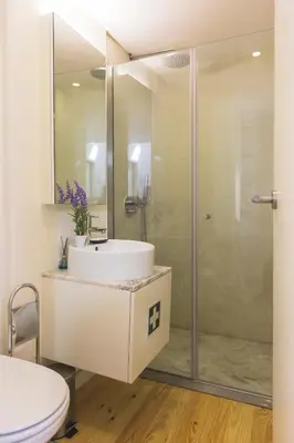 a bathroom with a sink and a shower at APOSENTUS - Your home with a remarkable view in Vila Nova de Gaia