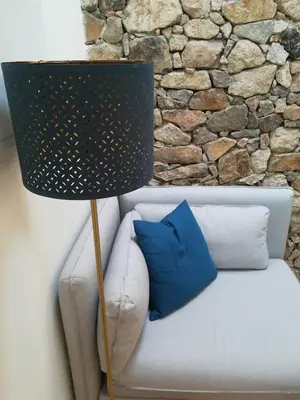 a lamp sitting on a white couch next to a stone wall at APOSENTUS - Your home with a remarkable view in Vila Nova de Gaia