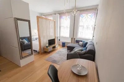 a living room with a couch and a table and a mirror at charm in C - Porto Center Apartment in Porto