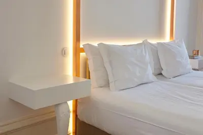 a white bed with white pillows and a white nightstand at Downtown Colosseum Apartments in Porto