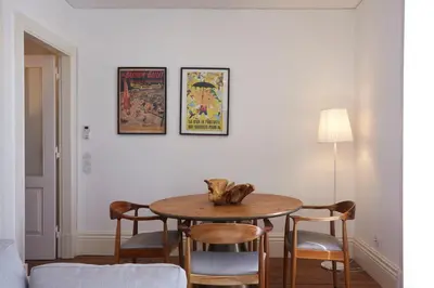 a table in a room with chairs and posters on the wall at Downtown Colosseum Apartments in Porto