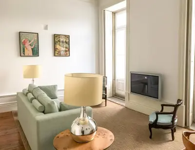 a living room with a couch and a table with a lamp at Downtown Colosseum Apartments in Porto