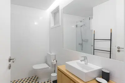 a white bathroom with a sink and a toilet at Douro Virtudes Apartments Historical Center in Porto