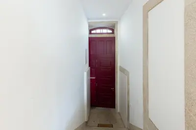 a red door in a white hallway at Douro Virtudes Apartments Historical Center in Porto