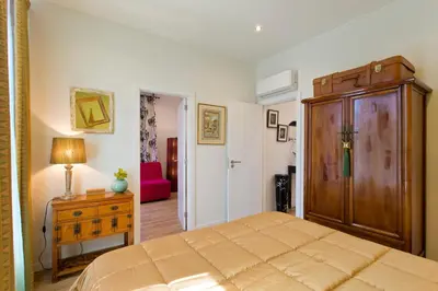 a bedroom with a large bed and a wooden cabinet at Luxurious Pink House and Parking in Porto