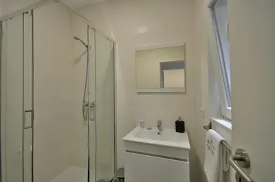 a white bathroom with a sink and a shower at Casa da Ana - Porto Velho Apt in Porto